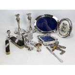 A collection of silver including two photograph frames, hand mirror, pair of candlesticks, small