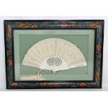 An ivory and lace fan with pierced and foliate detail, width approx 50cm, framed and glazed.