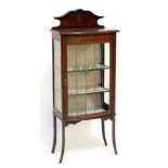An Edwardian mahogany bowfronted display cabinet with inlaid foliate detail, the glazed door