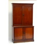 A late 19th century mahogany bookcase, the upper section with two doors enclosing arrangement of