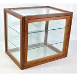 A 20th century glazed cabinet with hinged door and two glass shelves, height 40cm, width 46cm.