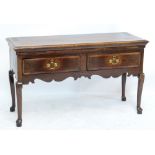 An oak two drawer dresser based raised on cabriole legs to pad feet and with shaped apron, width