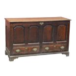 A George III oak blanket box with half hinged lid above four fielded panels, two drawers and stile