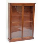 An early 20th century mahogany freestanding four shelf open bookcase with twin glazed doors, on