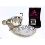HORACE WOODWARD & CO; an Edward VII hallmarked silver sauce boat with C-scroll handle on three