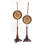 A pair of William IV rosewood pole screens, each with glazed circular floral embroidered panels