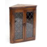 A reproduction oak wall flat fronted corner cupboard with pair of astragal glazed doors, height