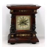 A German mahogany cased mantel clock, the dial set with Roman numerals and flanked by turned