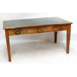 An early to mid-20th century mahogany three drawer writing table raised on square sectioned tapering