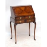 A reproduction walnut bureau of diminutive proportions, the book-matched veneered fall front