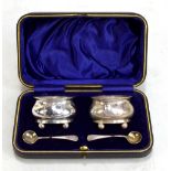 LEE & WIGFULL; a cased pair of Edward VII hallmarked silver oval open salts on four ball legs,