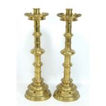 A pair of Victorian neo-Gothic style candlesticks with knopped stems and stepped circular bases with