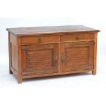A pine and oak Arts and Crafts style sideboard with two drawers above cupboard doors and raised on