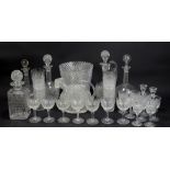 A small quantity of clear cut glass comprising decanters, various drinking glasses, and a vase.