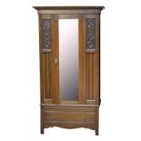 An Edwardian walnut wardrobe with single mirrored door and carved panel, width 105cm.Additional
