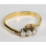 An 18ct yellow gold and diamond three stone crossover ring, each stone in claw setting weighing