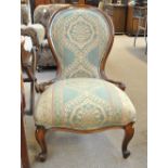 A late Victorian mahogany nursing chair with padded back and seat.