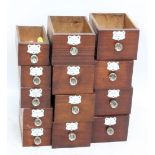 Thirteen mahogany fronted apothecary drawers with glass handles and white enamelled named plaques (