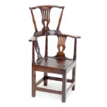 An 18th century and later ash, elm and pine corner chair with double height raised back, pierced