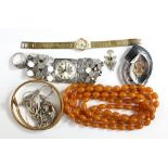 A small group of costume jewellery comprising gold plated snake bangle, string of amber coloured