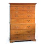 An early 19th century oak chest on chest with two short and six long drawers raised on squat bracket