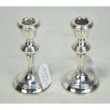 WI BROADWAY & CO; a pair of small Elizabeth II hallmarked silver candlesticks with tapering stems on
