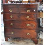 An early 19th century mahogany chest of two short and three long graduated drawers raised on bracket