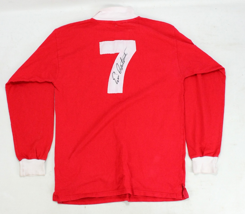 ERIC CANTONA; a signed replica 1970s Manchester United football shirt.