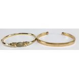 A 9ct yellow gold snap bangle with cubic zirconia navette shaped platform flanked by knots, aperture