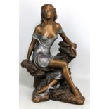 A modern decorative bronzed spelter figure of a woman sitting upon a rock, signed 'Alice Heath',