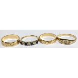 Two 9ct yellow gold bands and two 9ct dress rings set with stones, combined approx 7.2g.