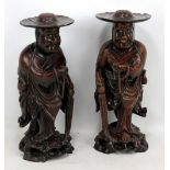 An opposing pair of 19th century Chinese carved root wood figures of Mahayana monks holding beads,