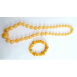 A polished Baltic amber expandable bracelet, and a pale amber coloured graduated bead necklace,