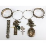 A small group of silver jewellery to include two snap bangles, a large locket pendant, an ingot, and
