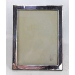 J & R GRIFFIN LTD; a George V hallmarked silver rectangular photo frame of plain form, Chester 1914,