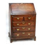 An early 18th century oak bureau, the fall-front enclosing a refitted interior with base of two