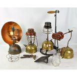 Four early 20th century pump paraffin lamps including a copper example with circular back plate,