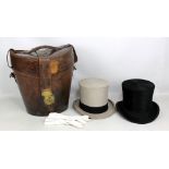 An Edwardian leather double hat box containing a grey and a black top hat, height 39cm.Additional