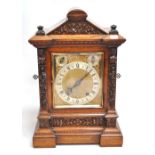 WINTERHALDER & HOFMEIER; an oak cased mantel clock with carved foliate decoration, the silver