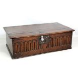An early 18th century oak bible box with simple hinged lid above carved front panel, width 63.5cm.