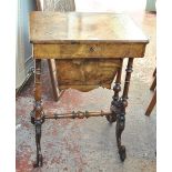 A Victorian walnut and inlaid sewing table with hinged lid, basket beneath and turned supports,