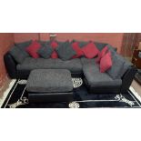 SEDUTA D'ARTE; a black leather corner sofa and a pouffe with canvas cushions.