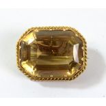 A yellow metal framed brooch set with cushion cut citrine with safety chain, 3 x 2.5cm, approx