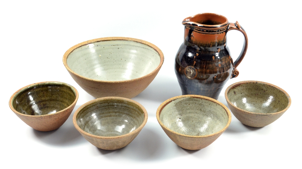 Leach Pottery; a stoneware jug covered in tenmoku breaking to khaki glaze, impressed pottery mark,