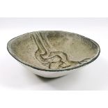 PETER WRIGHT (1919-2003); a stoneware dish decorated with stylised interlocking figures in relief