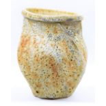 CHRIS CARTER (born 1945); a faceted oval stoneware vessel covered in textured and heavily pitted