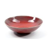 RUPERT SPIRA (born 1960); a small stoneware bowl covered in red copper glaze, impressed RS mark,