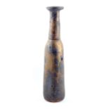 ROBIN WELCH (born 1936); a tall stoneware bottle with elongated neck covered in running bronze glaze