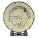 RUPERT SPIRA (born 1960); an early stoneware plate decorated with grasses on a speckled grey ground,