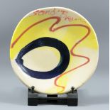 SANDY BROWN (born 1946); a colourful and decorative stoneware plate, painted signature, diameter